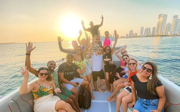 Grupo celebrando en un bote en la bahía al atardecer