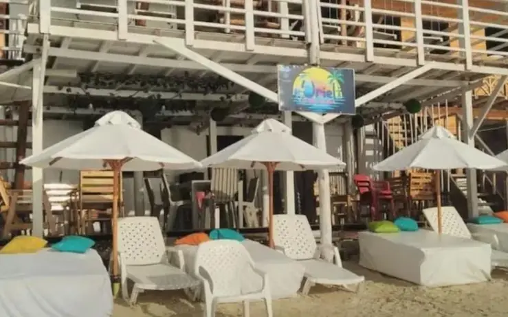 Zona de playa con sombrillas y camas en Playa Tranquila Uriel