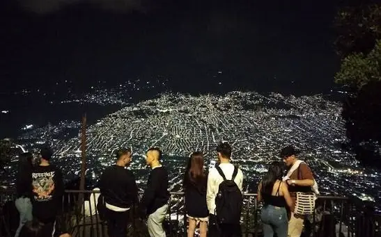 Grupo en un mirador viendo Medellín iluminada de noche